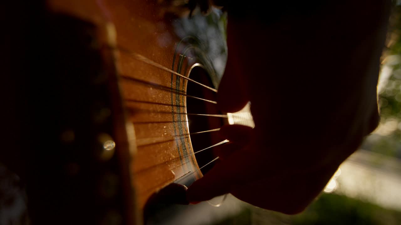 Close-up of a person playing acoustic guitar