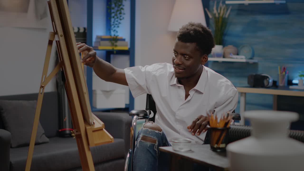 African american adult in wheelchair using pencil on canvas