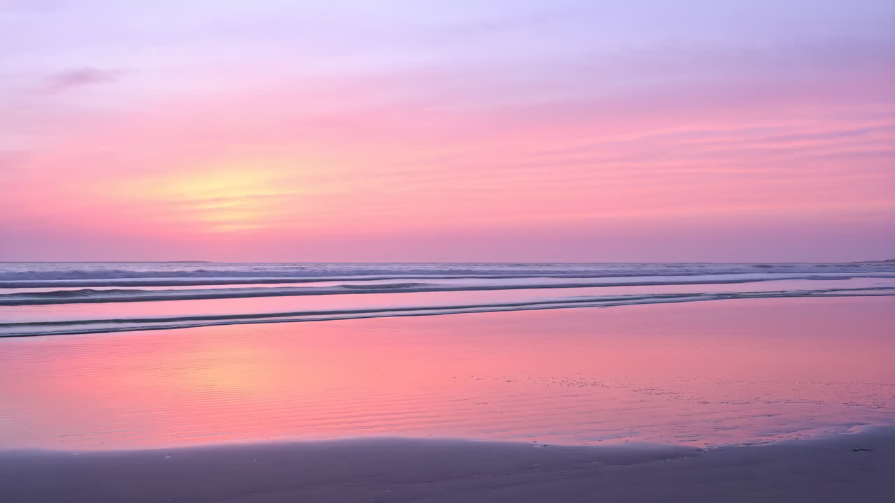 Vibrant Pink and Purple Sunset Reflection on a Tranquil Beach