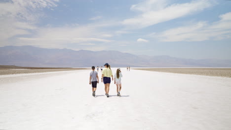 people walking across a vast salt flat in a desert landscape