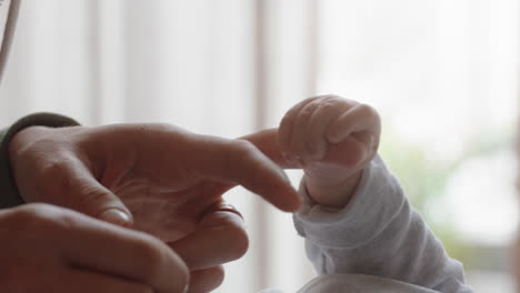 madre sosteniendo al bebé con la mano tocando los dedos cuidando al recién nacido cuidando del bebé en casa disfrutando de la maternidad