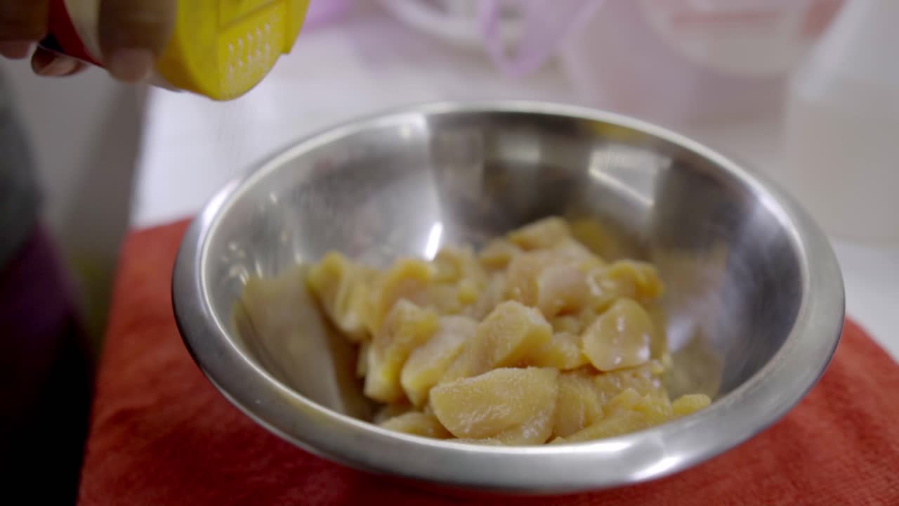 Mani che preparano pezzi di pollo con limone in una ciotola durante il processo di cottura