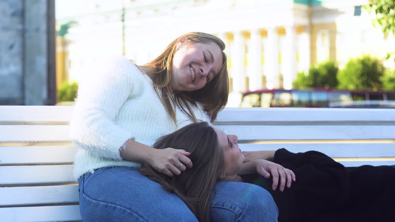 두 명의 여성이 벤치에서 휴식을 취하고 있습니다.