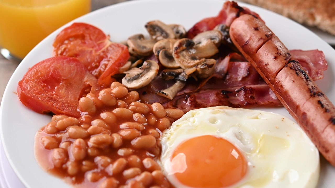 Colazione inglese completa con uovo fritto, pancetta, salsicce e fagioli
