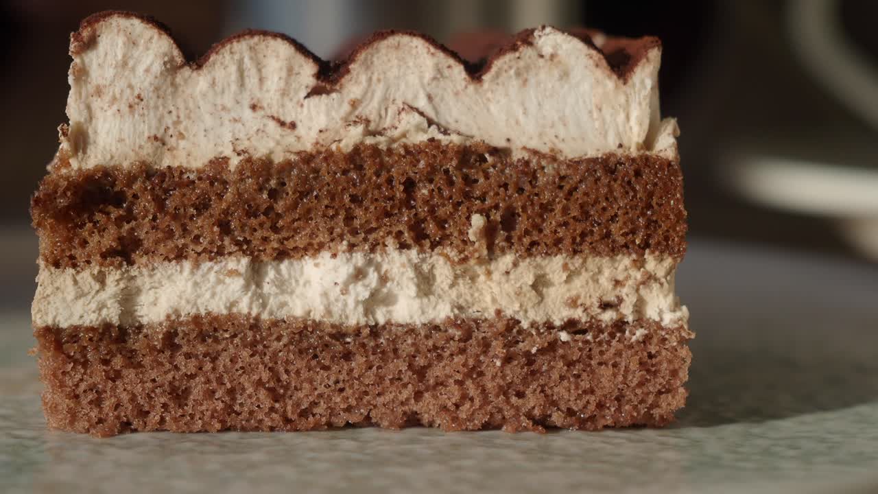 Primo piano di una fetta di torta a strati al cioccolato e crema.