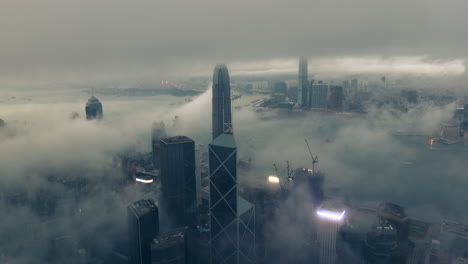 morning fog surrounding the international finance center in hong kong, sinister cinematic wide drone shot