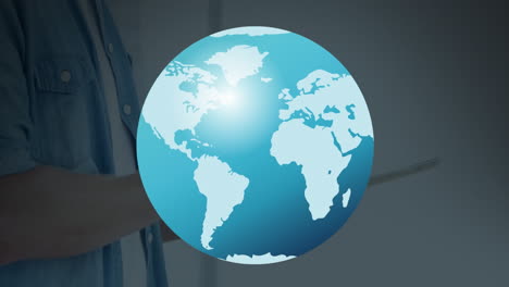 animation of globe over hands of caucasian man using tablet