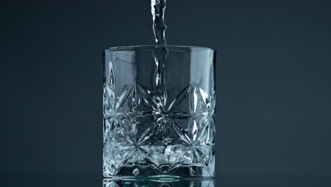 water stream filling glass closeup. crystal clear beverage pouring beautiful cup