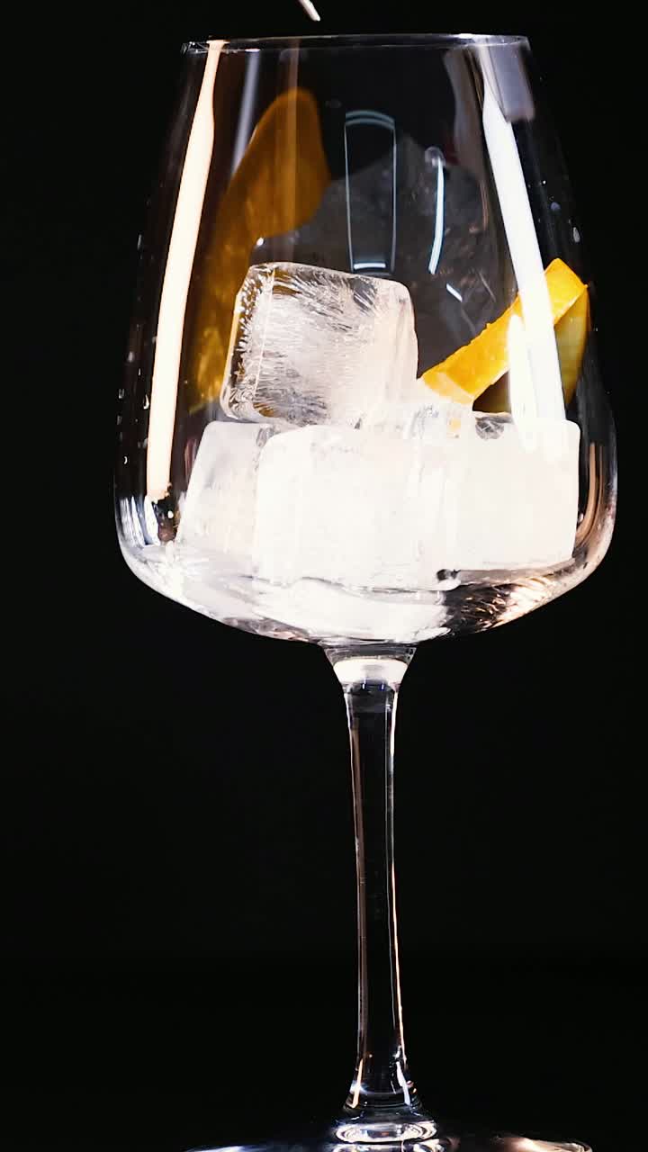 Bicchiere con ghiaccio e fetta d'arancia, mescolato