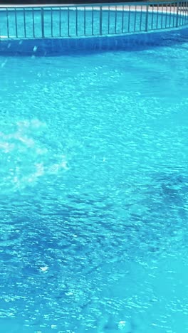 man jumping in swimming pool at sunny day.