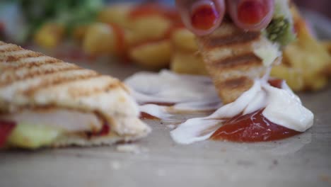 primer plano de un sándwich de queso a la parrilla, papas fritas, ketchup y mayonesa
