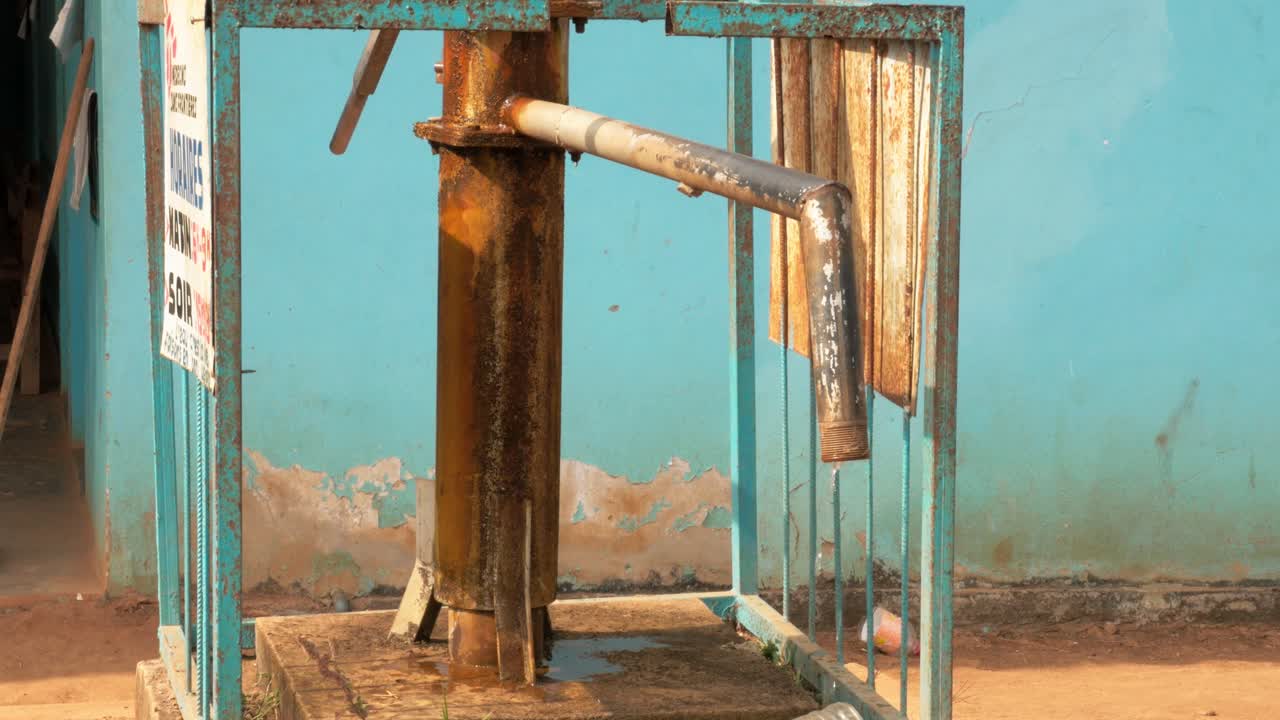 Old manual water pump for water supply in a rural hospital courtyard in Cameroon. Static shot