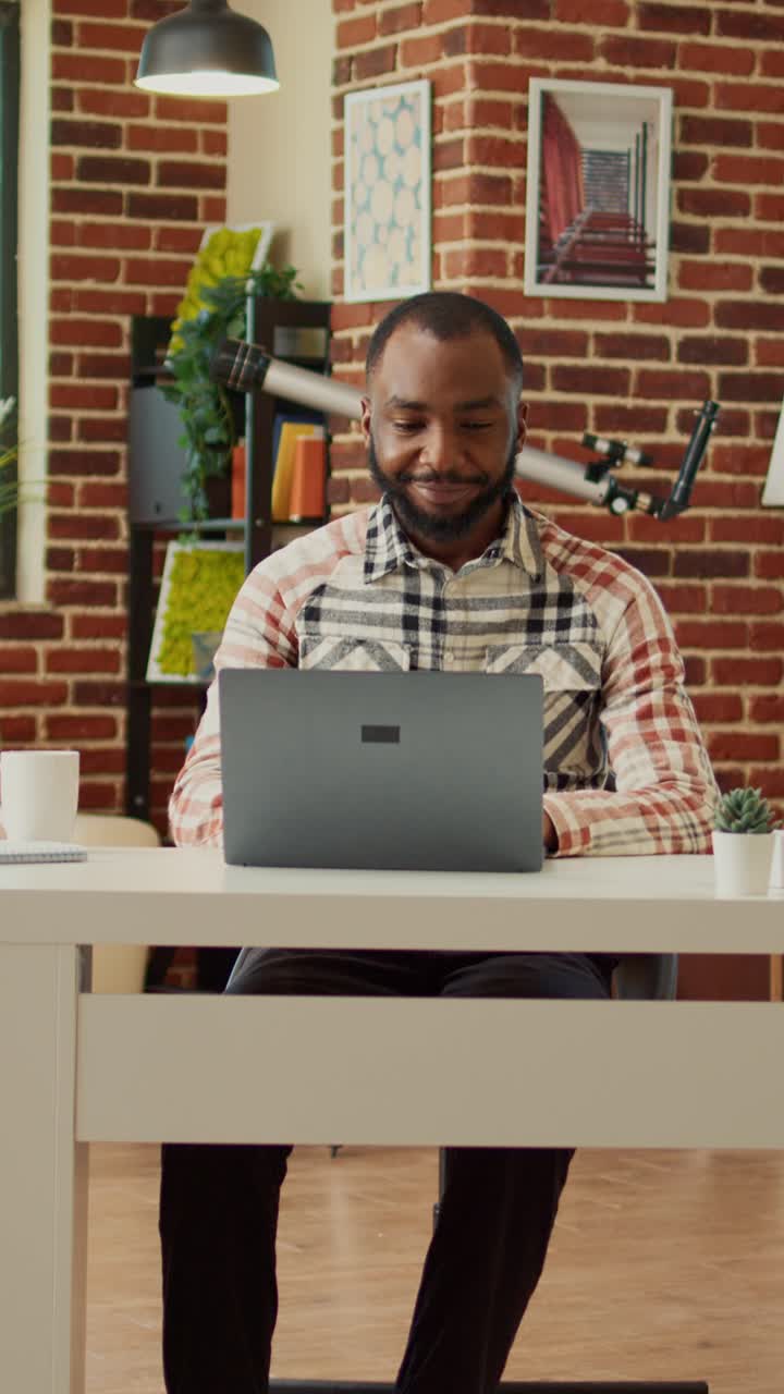 Vertical video: Young adult sitting at desk to work on freelance with laptop
