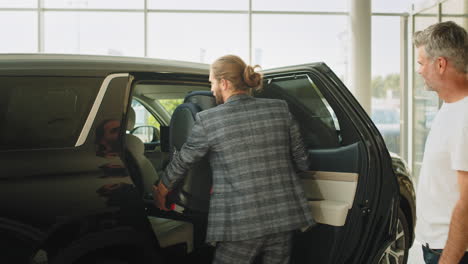 customer and salesman in car dealership