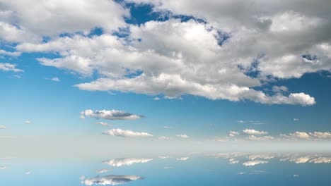 futuristic background consisting of time lapse clip of white fluffy clouds over blue sky and their reflection, video loop