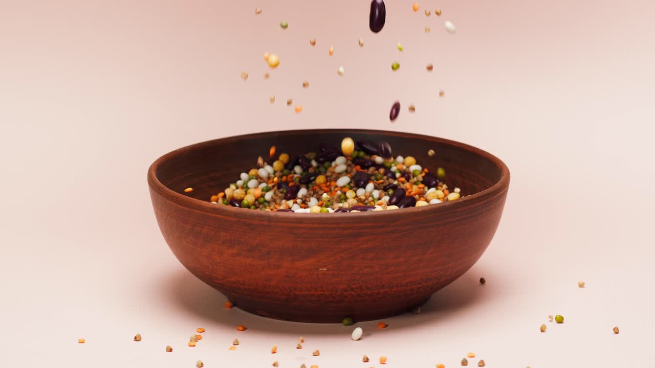 Hands Scooping and Pouring Mixed Legumes into a Ceramic Bowl