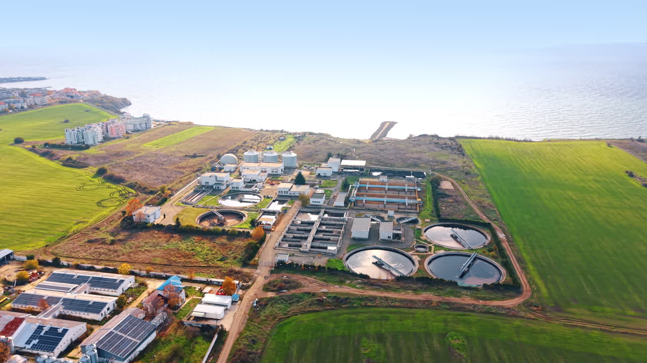 Large wastewater treatment plant in the fields at the seashore. Modern facility for recycling and reuse of water. Aerial view