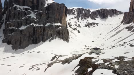 casa en la montaña en un valle nevado rodeado de altos picos de dolomita