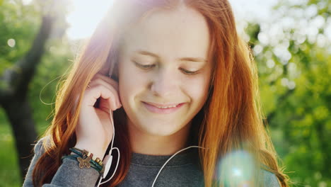 cute red-haired teenage girl listening to music on headphones 1