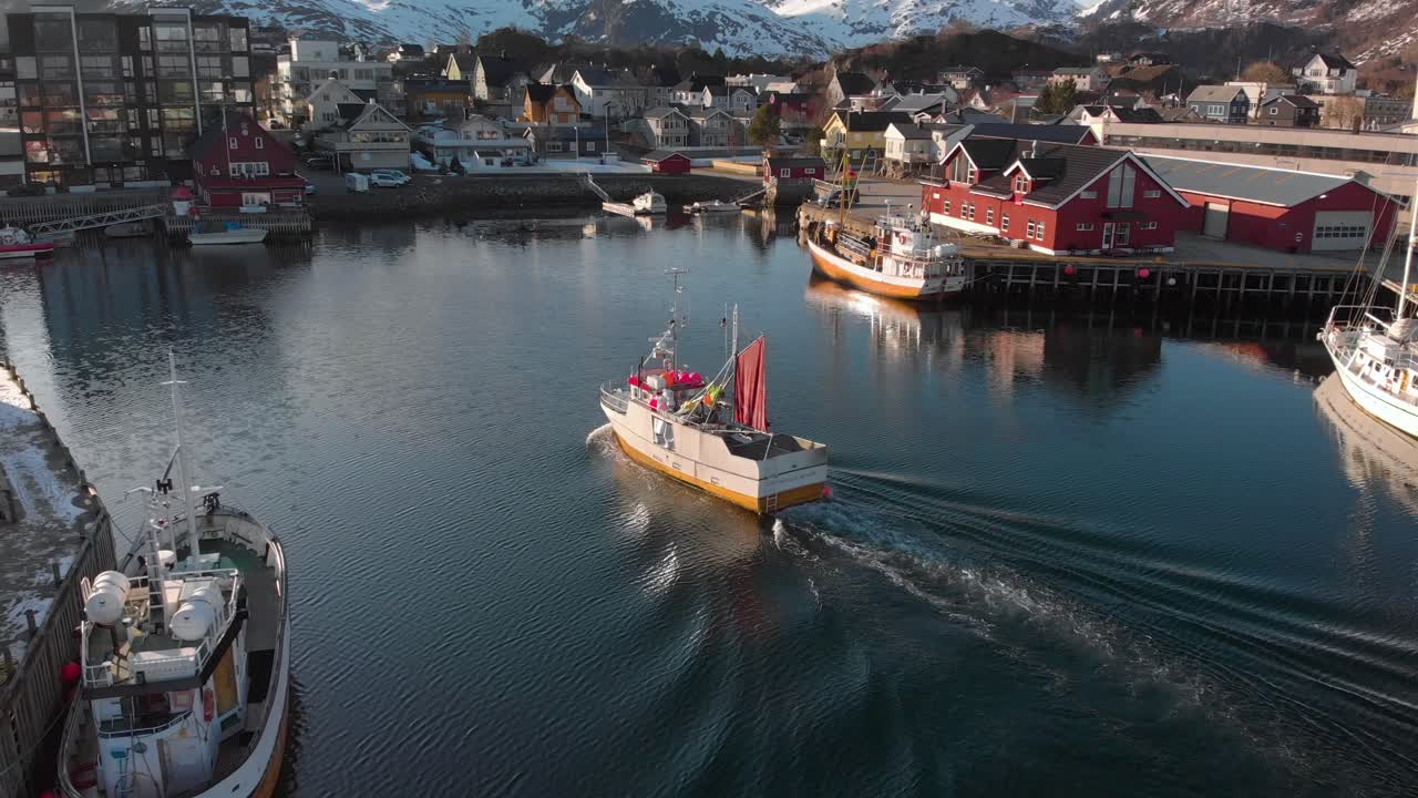 Aerial drone shot of a small fishing boat going in to the docks in Lofoten Norway