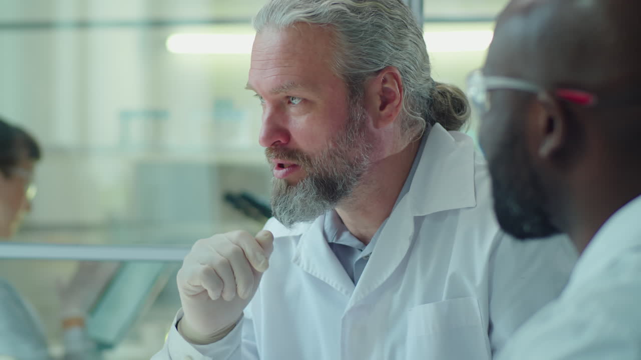 Senior Scientist Discussing Micrograph on Computer with Colleague
