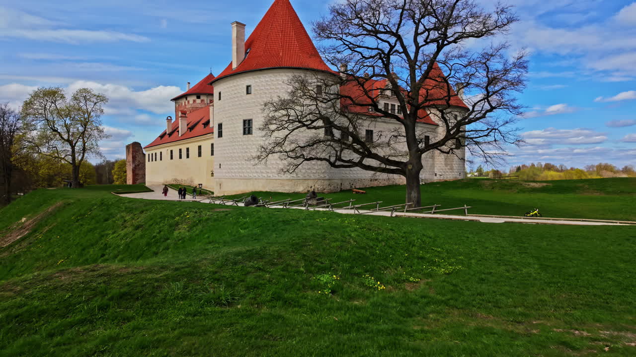 라트비아의 이 많은 날에 은 지붕과 초록색 주변을 가진 역사적인 바우스카 성