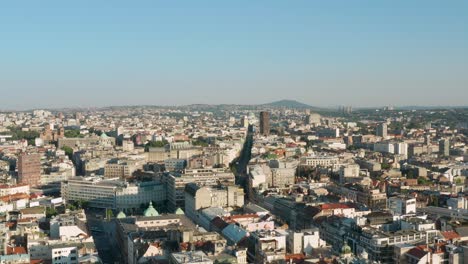 Aerial:-view-over-Belgrade-city-skyline,-Serbian-summer-day,-lowering-drone-shot