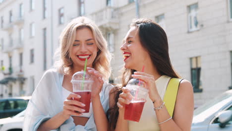 happy friends enjoying drinks on the street