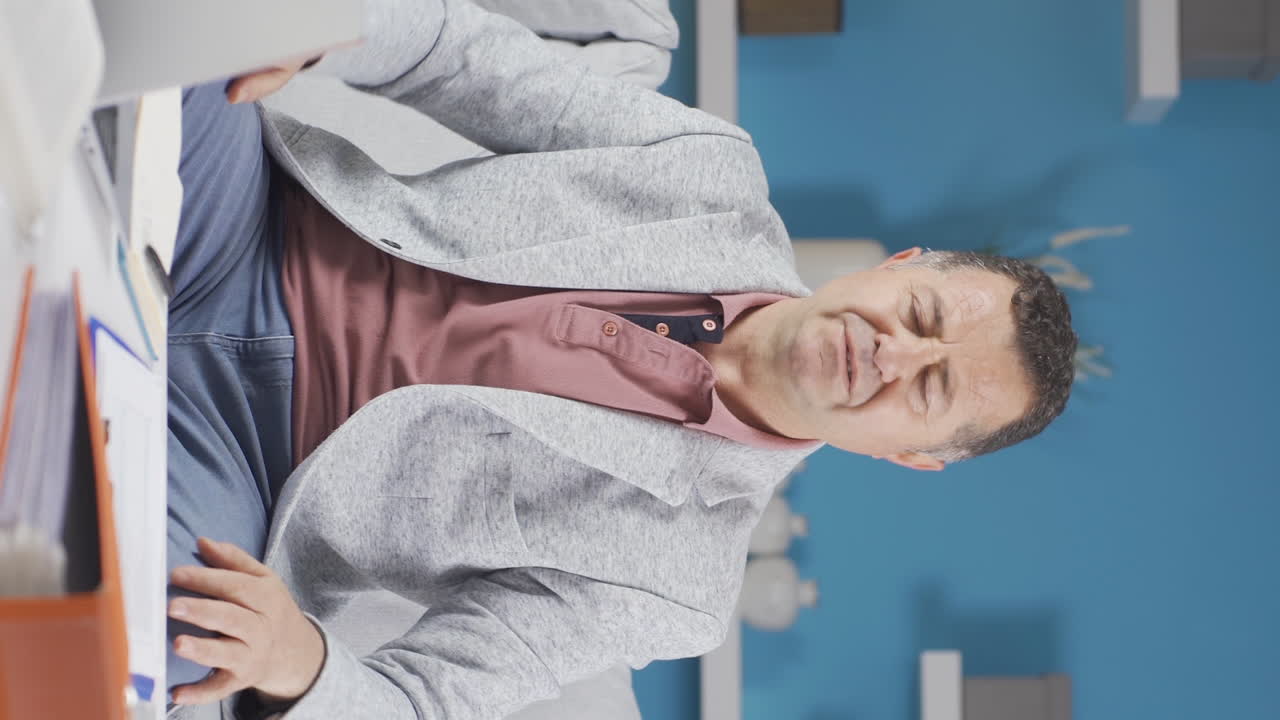 Vertical video of Home office worker old man despairing.