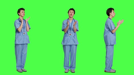 미소 짓는 의료 보좌관이 스튜디오에서 누군가에게 박수를 치고 있습니다.