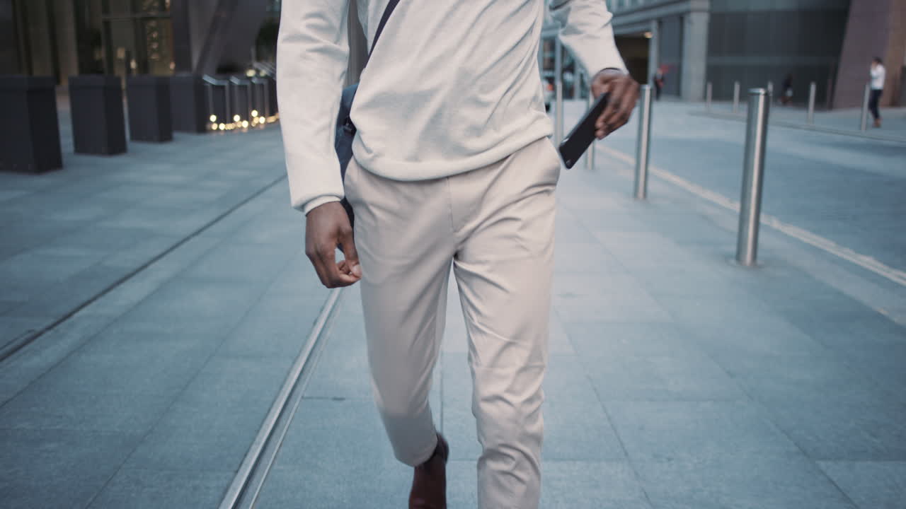 African American businessman walking through city using smart phone