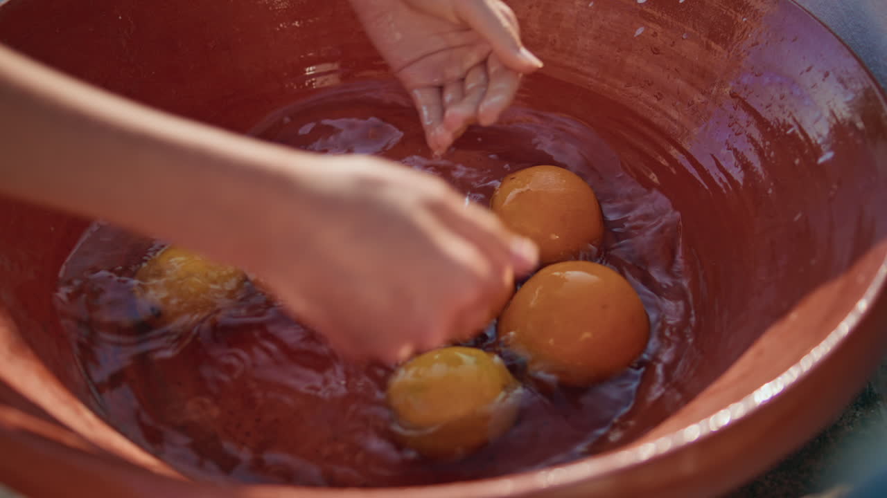 Manos de mujer limpiando frutas en un cuenco en un primer plano de pueblo. Mujer lavando naranjas.