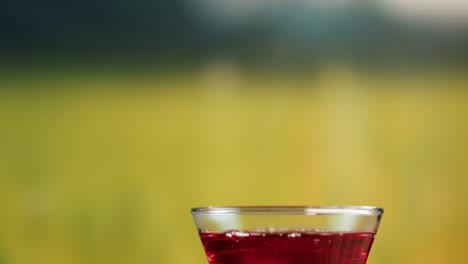 red liquid being poured from a teapot into a glass