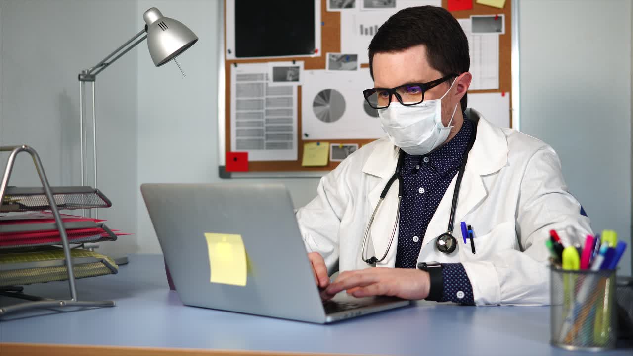 médico trabajando en la computadora portátil durante la pandemia