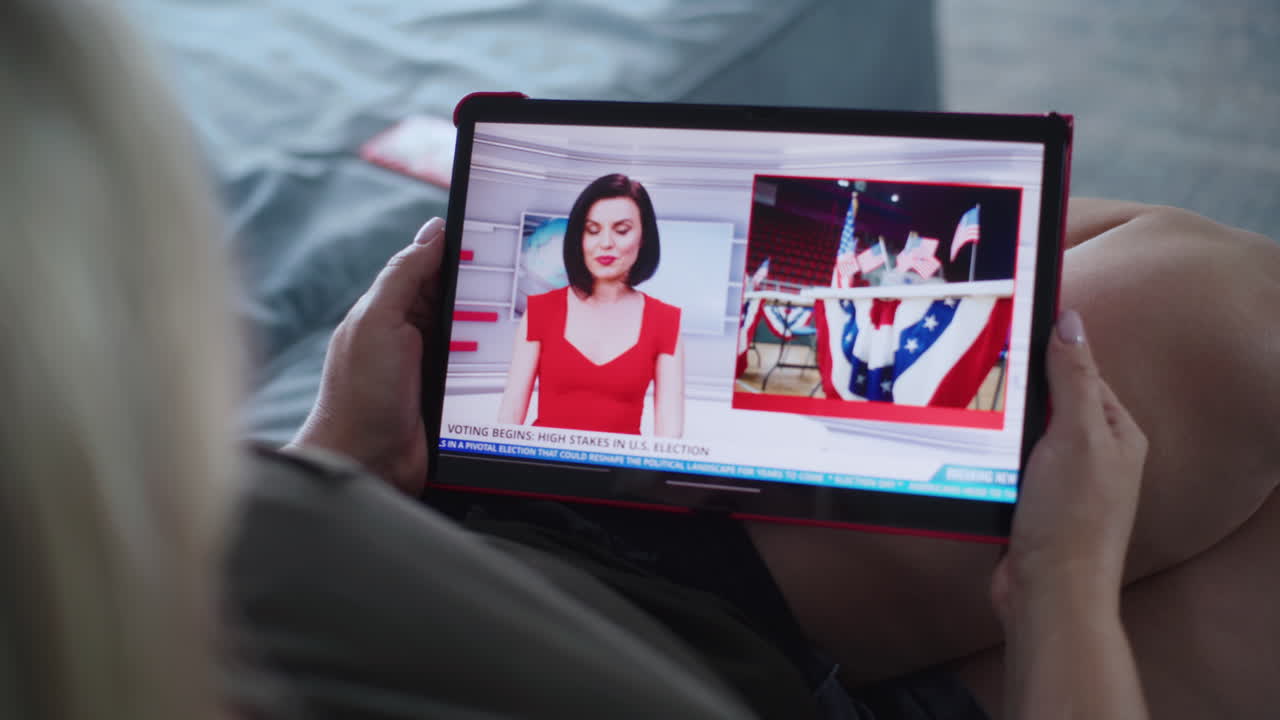 mulher a ver as notícias das eleições no tablet.