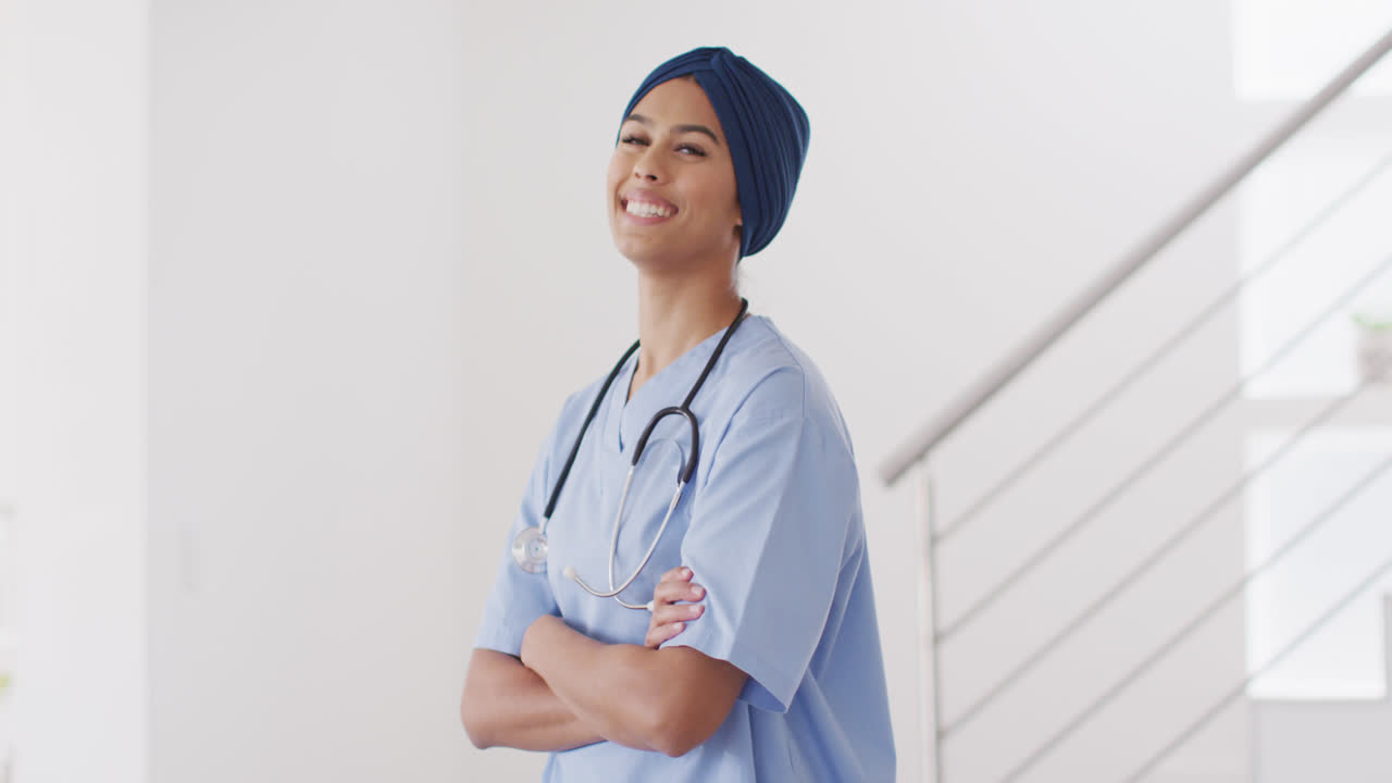 video de una feliz médica biracial con hijab mirando a la cámara