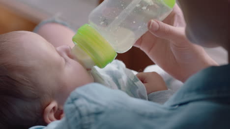 madre feliz alimentando al bebé bebiendo de la botella de leche madre amorosa cuidando del bebé disfrutando de la maternidad relajándose en casa