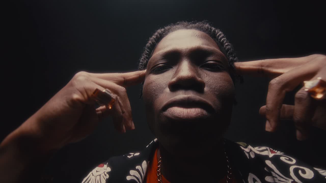 Stylish Black Man Bobbing Head to Hip-Hop Music with Fingers on His Temples