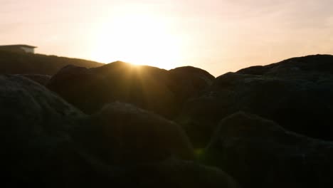 Bengalas-De-Lente-De-Puesta-De-Sol-En-El-Borde-De-Las-Rocas-En-La-Playa-Durante-Un-Paisaje-épico-Y-Dramático-Geológico-Ligero