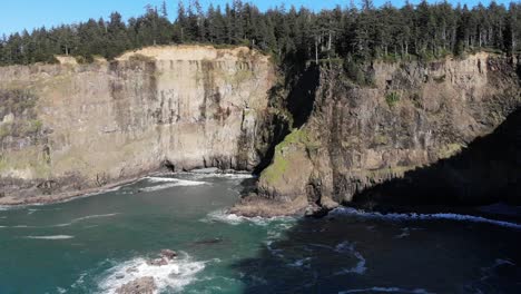 drone flies toward the shadows in a cove on the ocean