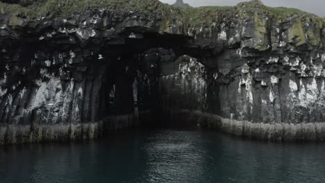 incredible low angle view of natural stone bridge in iceland with birds, aerial