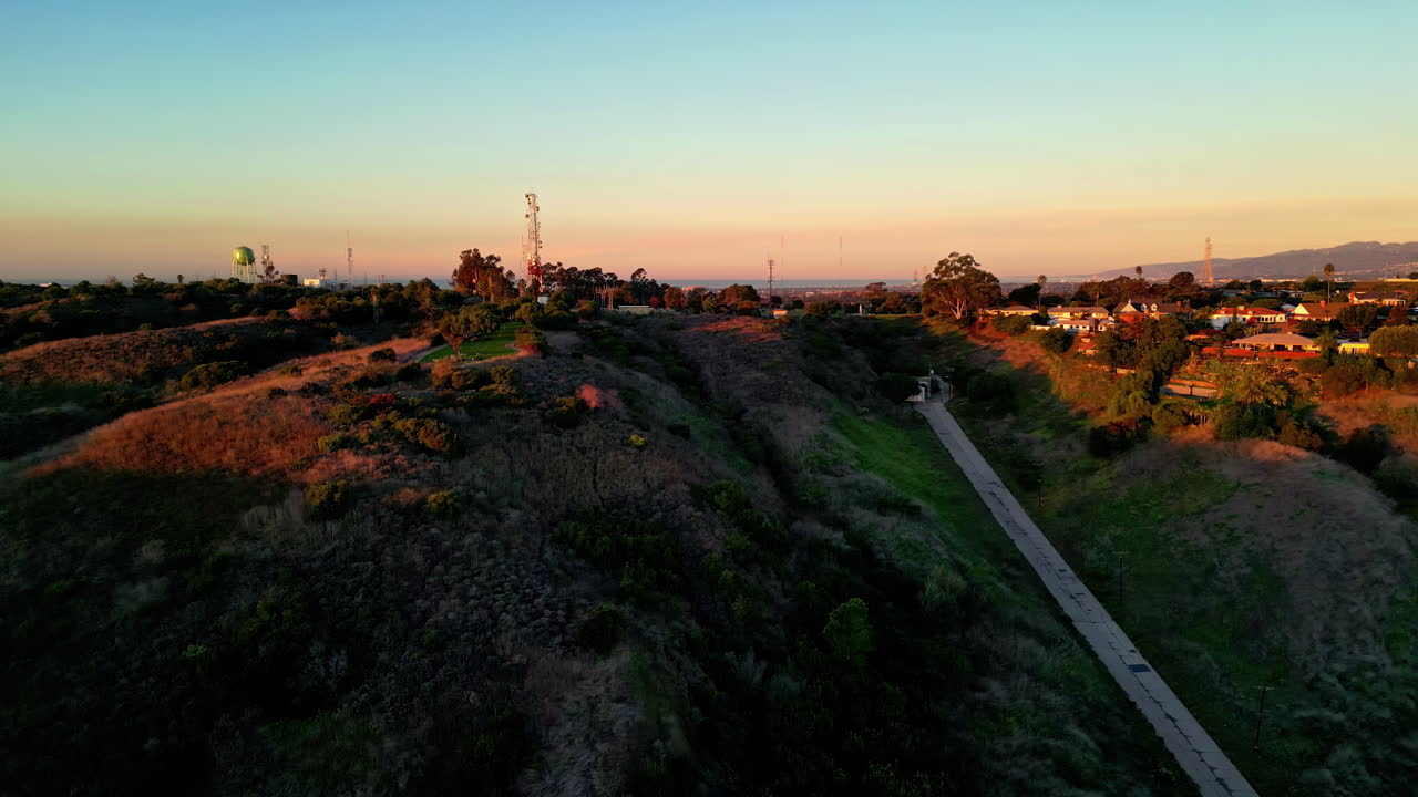 항공 드론은 저녁 시간 동안 언덕을 따라 마을 집 위를 향해 앞으로 이동