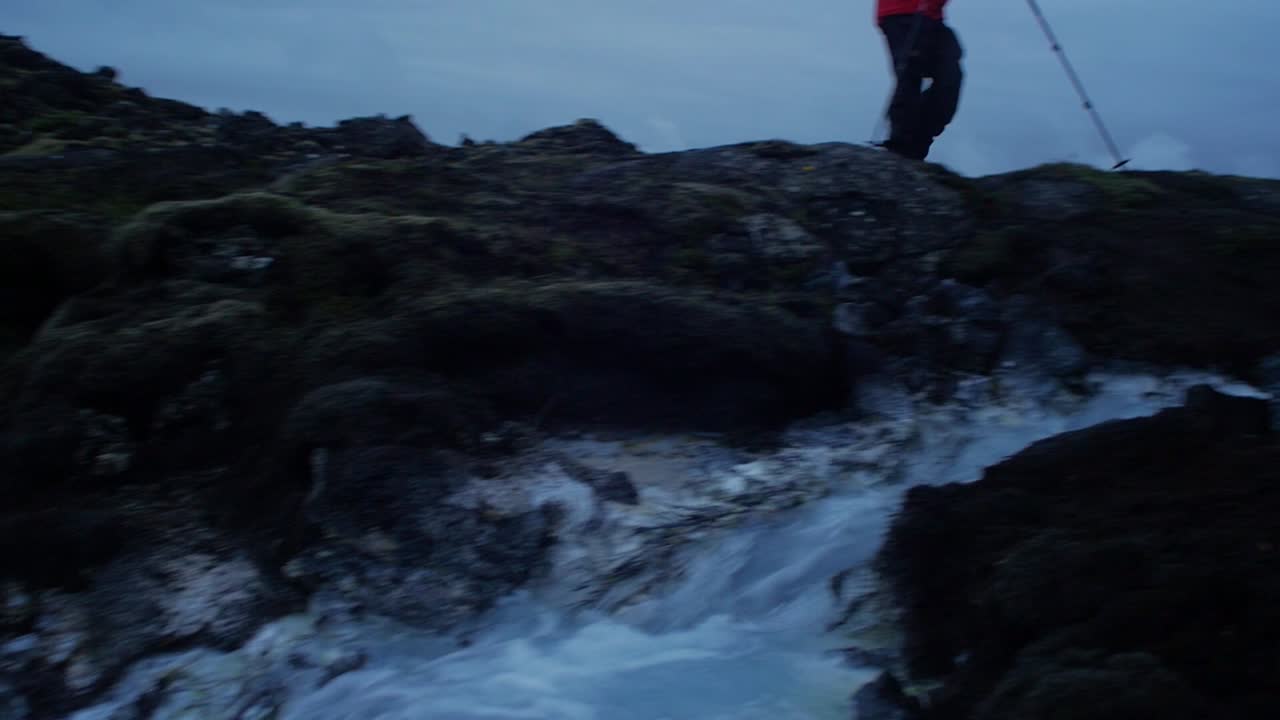 iceland landscape, blue lagoon at night, svartsengi power plant, one person walking around the blue water, camera movement, camera following-tracking on a steadicam gimbal stabiliser, wide angle lens