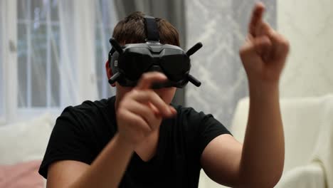 young man with goggles vr eyewear in virtual reality tapping with hands on invisible screen