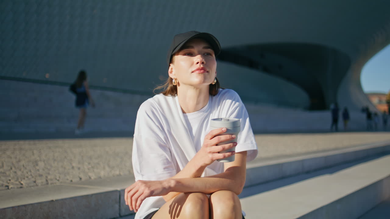 Carefree lady drinking coffee sitting sunny urban stairs closeup. Relaxed woman