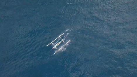 a small white boat moving swiftly in the blue ocean aerial view