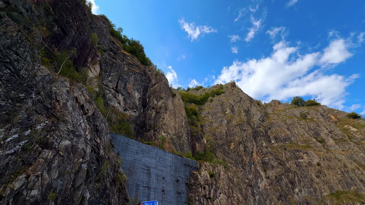 Steep rocky cliffs near Vidraru Dam in Romania. Dramatic rocky cliffs rising into the sky at Vidraru Dam, Romania