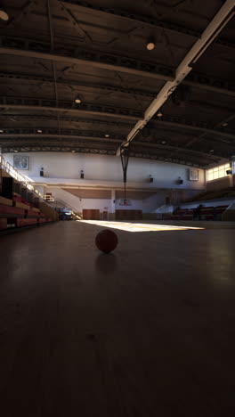 an empty basketball court with a basketball in the center.