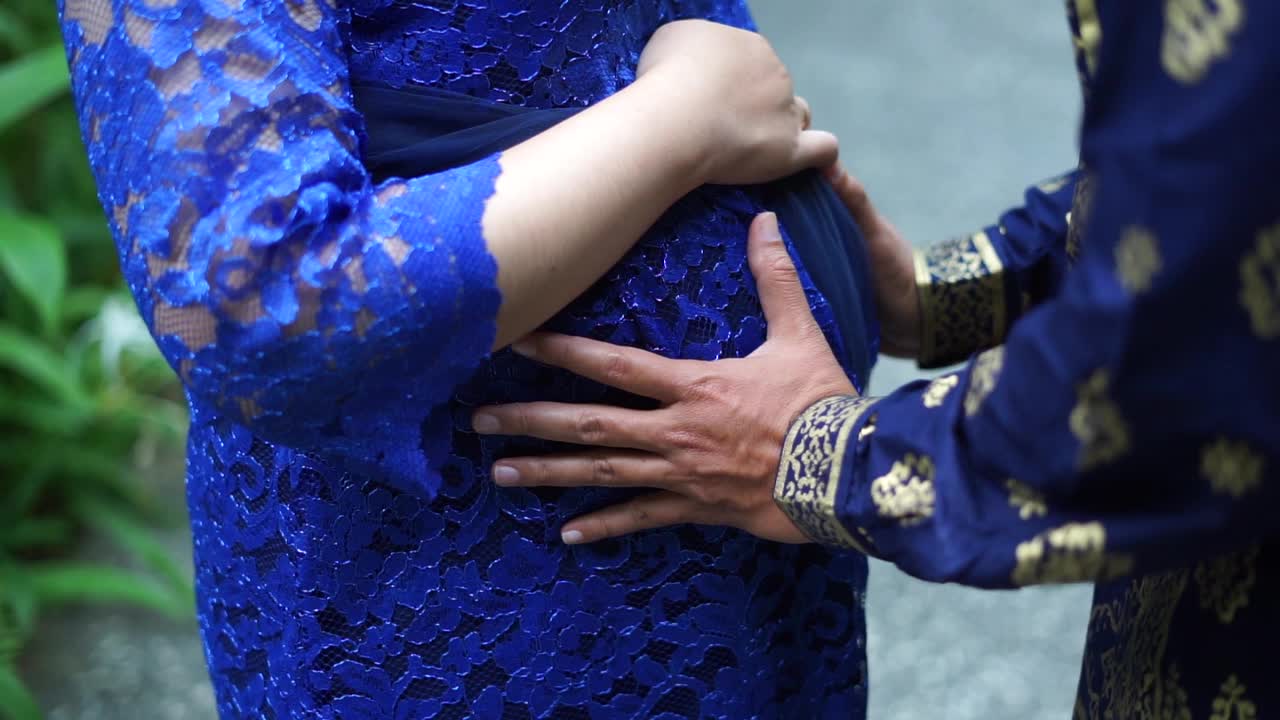 la mano de un hombre acaricia un vientre embarazado