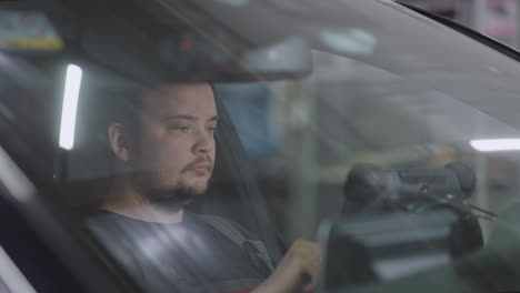 male mechanic uses a tablet computer with an augmented reality diagnostics software. specialist inspecting the car in order to find broken components inside. male uses laptop for diagnostics